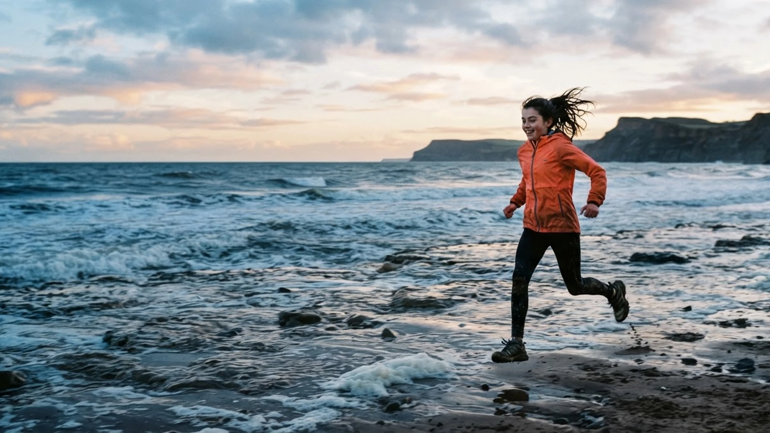 Young person running beside the sea on the Yorkshire coast